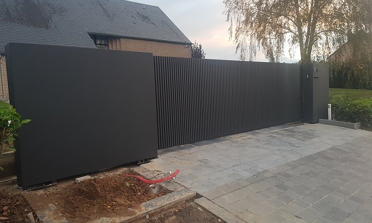 Moderne schuifpoort met verticale kokers en vaste panelen - Faimes