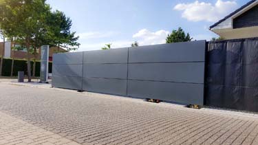 Moderne stalen schuifpoort met aluminium panelen en grote apatie