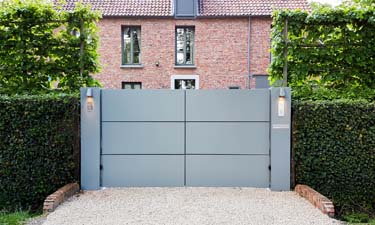 Moderne aluminium vleugelpoort met twee brede zuilen te Antwerpen