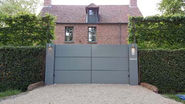 Moderne aluminium vleugelpoort met twee brede zuilen te Antwerpen