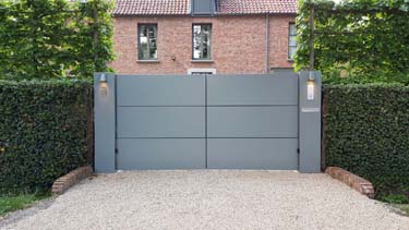 Moderne aluminium vleugelpoort met twee brede zuilen te Antwerpen