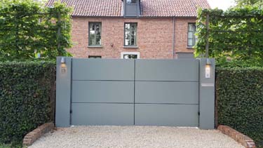 Moderne aluminium vleugelpoort met twee brede zuilen te Antwerpen
