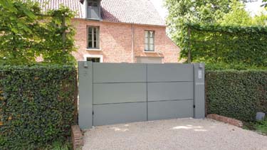 Moderne aluminium vleugelpoort met twee brede zuilen te Antwerpen