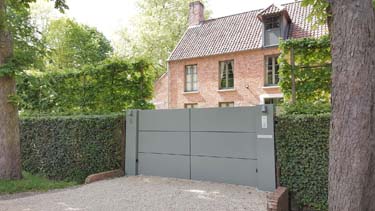 Moderne aluminium vleugelpoort met twee brede zuilen te Antwerpen