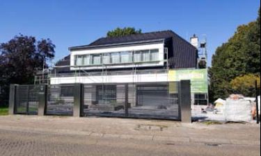 Strakke vleugelpoort bestaande uit stalen horizontale lammellen en RVS palen
