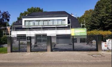 Strakke vleugelpoort bestaande uit stalen horizontale lammellen en RVS palen