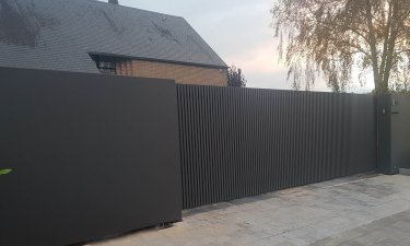 Moderne schuifpoort met verticale kokers en vaste panelen - Faimes